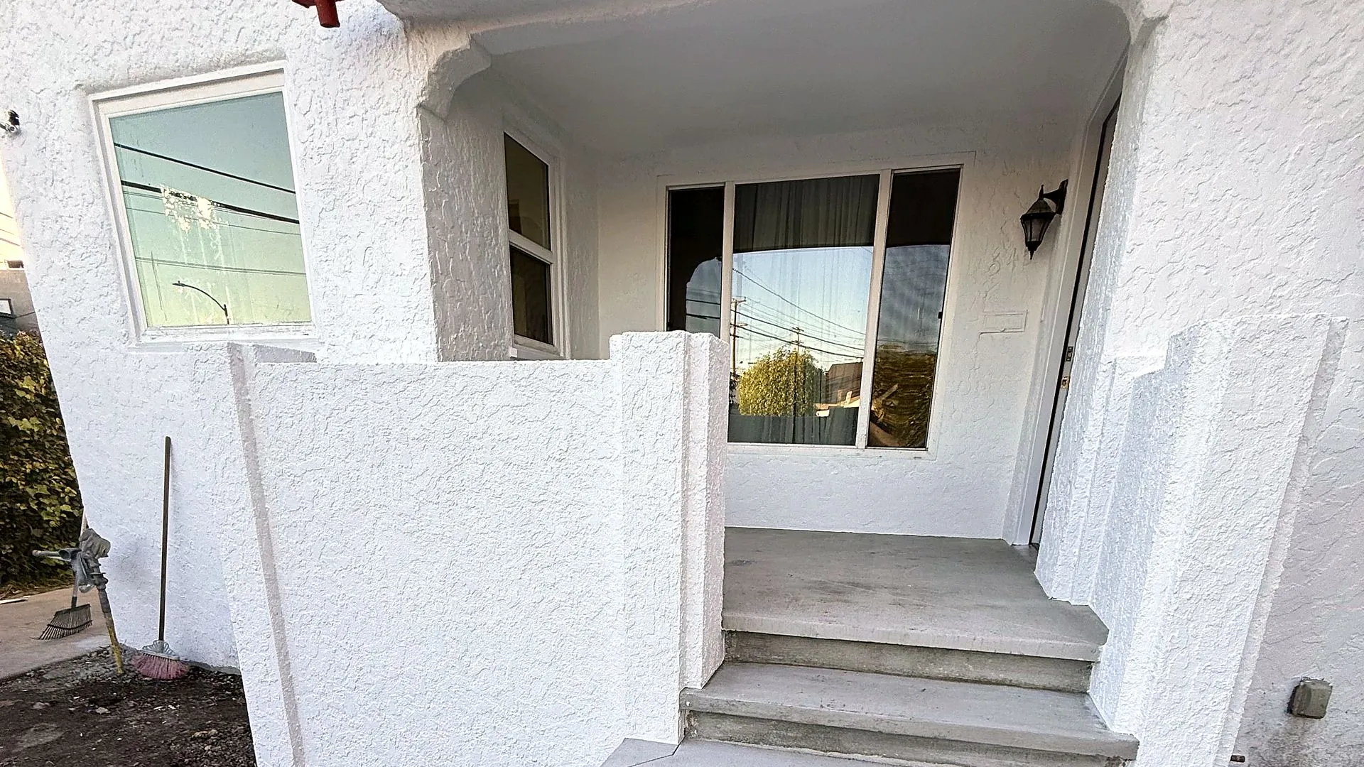 White stucco porch with new concrete steps and a red tile roof