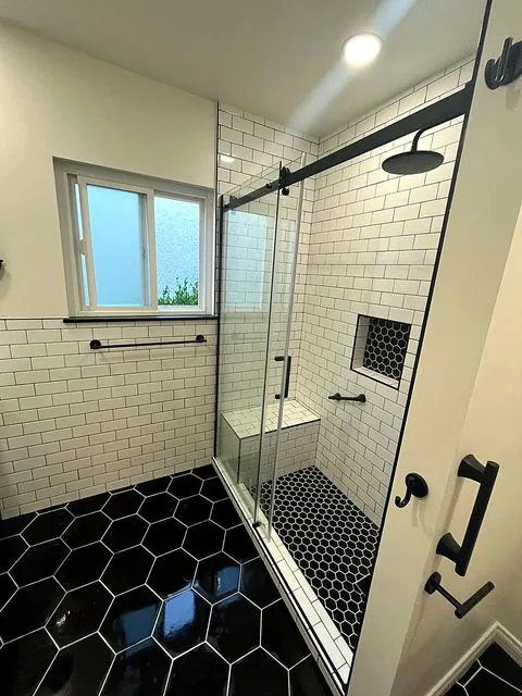 Subway tile shower with black hexagon floor